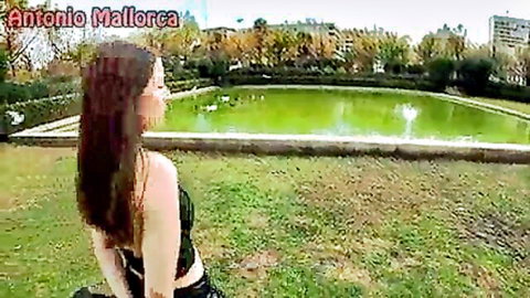 Brunette woman in black crop top posing by green pond in park, stranger pickup tease