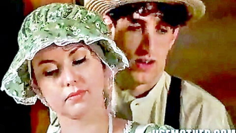 Jessie in green Amish bonnet with curly-haired man embracing her from behind