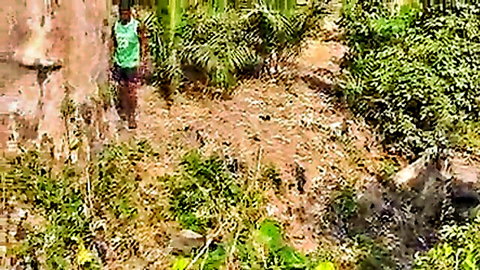 Teenage African village girl in green tank top by river, outdoor tease