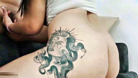 Juicy bare big ass closeup with intricate Medusa snake tattoo on lower back and cheeks
