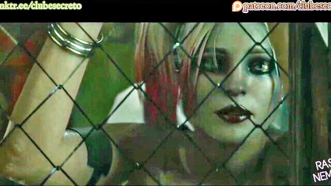 Harley Quinn cosplay babe with pink hair peering seductively through chain-link fence