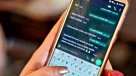 Woman's hand holds phone showing WhatsApp sexting chat with 'moan more' dirty talk messages