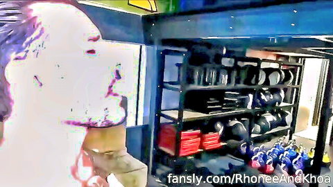 Shaved head muscular man in gym with weights shelves and fansly watermark