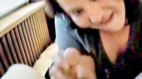 Smiling brunette gives sensual handjob to hard cock closeup