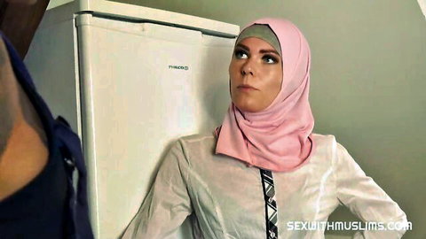 Sexy Muslim babe in pink hijab with man's arm in intimate kitchen pose