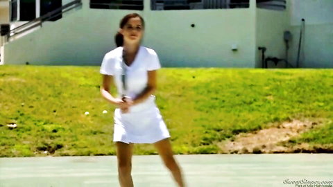 Brunette tennis babe in short white skirt and tank top serving racket on outdoor court