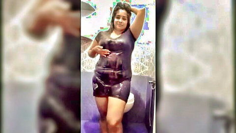 Indian model Arya in shiny black dress posing in bathroom, big boobs
