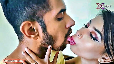 Bearded Indian stud passionately French kissing sexy brunette beauty with tongues out in steamy embrace