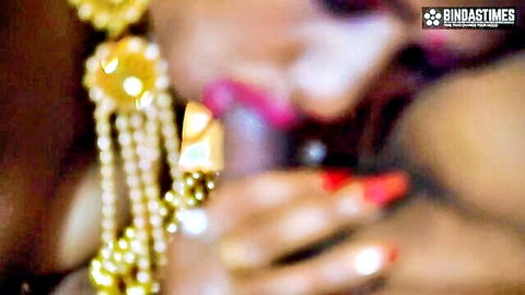 Blurry close-up of Desi woman in gold earrings and red nails teasing