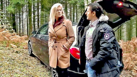 Blonde woman in trench coat with man by car in forest, teasing outdoor encounter