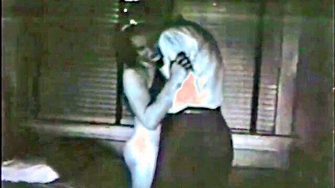 Nude blonde with big tits presses naked body against clothed man's back in intense vintage rough sex embrace