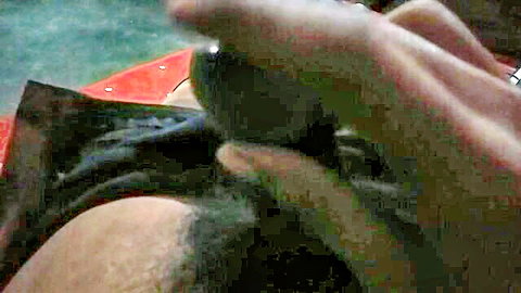 Close-up of hands inserting black dildo into tight ass for intense anal play