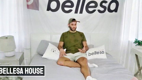 Hot guy in green shirt and shorts sits spreading legs on Bellesa House bed for casting cock tease