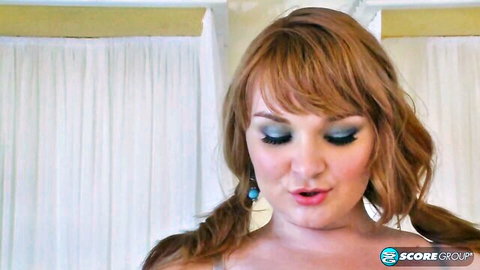 Sexy redhead with pigtails and smokey eyes teases with glossy puckered lips closeup
