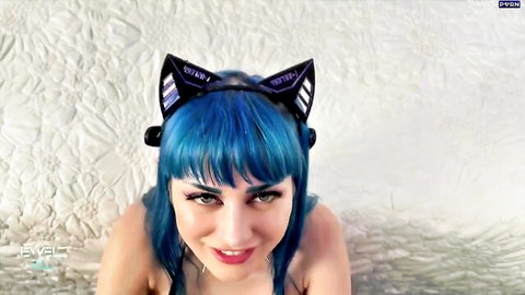 Blue-haired e-girl in neon cat ears smiling seductively on bed teasing viewers