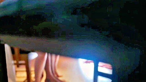 Blurry Indian woman bent over in tailor shop, teasing exposure