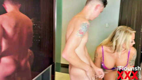 Blonde busty babe in purple lingerie grabs tattooed hunk's cock and balls by mirror