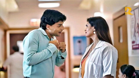 Excited Indian man gestures fists at attractive doctor woman in white coat hospital hallway