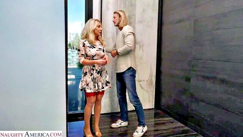 Blonde woman in short floral dress flirts with long-haired man