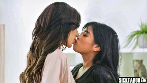 Two sexy Asian brunettes passionately French kissing while clothed in tops