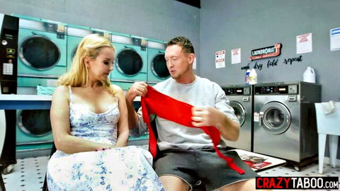 Blonde with medium tits in floral dress playfully holds red cloth with guy in laundromat