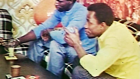 Vintage 1970s black men in casual shirts relaxing on couch