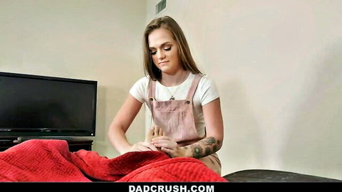 Joey White in white tank and pink overalls, sitting on bed teasing vibe