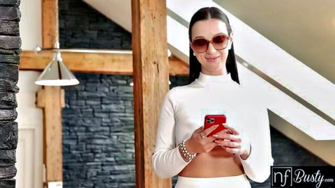 Busty MILF in tight white crop top and pants posing with phone seductively