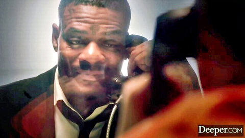 Intense black man in suit on phone, starring in Anna Claire Clouds' BBC begging scene