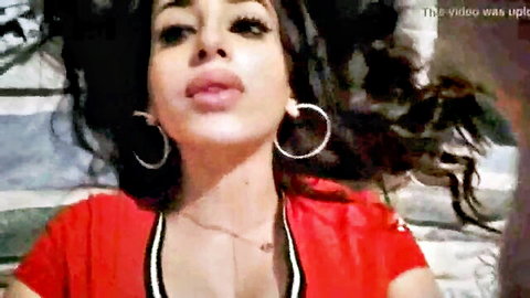 Seductive Arab woman in red top and hoop earrings, lying back teasingly
