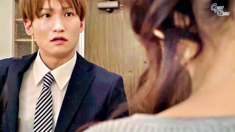 Shocked suited Asian man stares at curvy long-haired brunette woman from behind in room