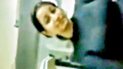 Blurry amateur closeup of Arab woman in blue scrubs with intense surprised expression