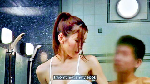 Busty Japanese brunette in white top leans over blurred man's lap in steamy sauna shower