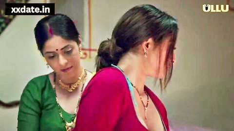 Indian bhabhi in green saree hugs friend in pink blouse, deep cleavage, intimate pose