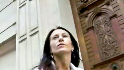 Brunette woman looking up with open mouth teasing blowjob near ornate door