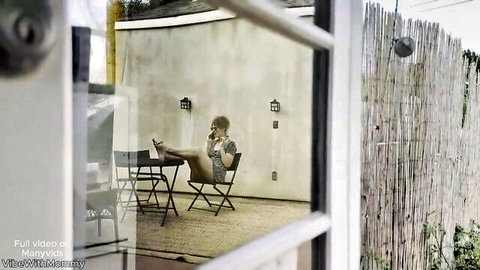 Sexy woman spreads legs wide on patio chair talking on phone tease