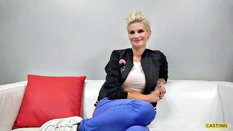 Petra from Czech Casting, blonde model in casual jacket and pants, smiling on couch