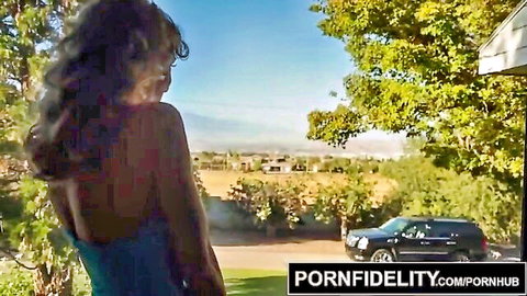Brandi Love in tight blue backless dress, scenic outdoor view