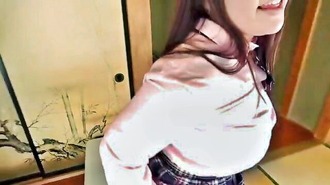 Busty Japanese schoolgirl smiling seductively in tight white blouse and plaid skirt in tatami room