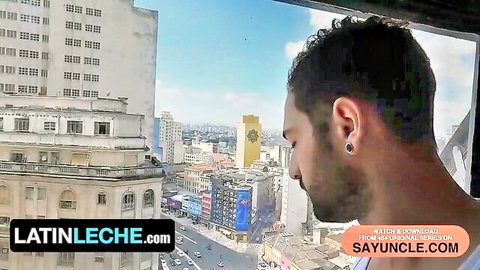 Igor Lucios side profile in Brazilian city high-rise, curly hair and earring, Latin Leche teaser