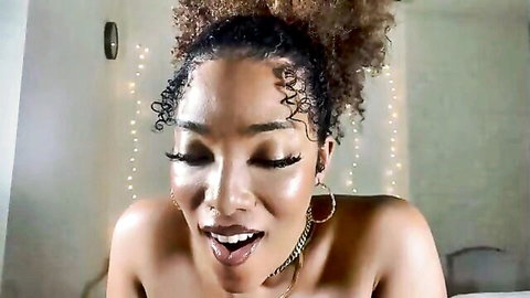 Ebony babe with voluminous curly hair and glossy lips wide open topless moaning seductively