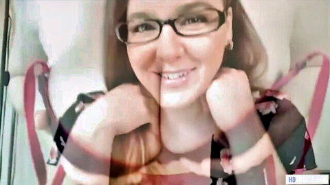 Brunette tech support woman smiles on webcam in floral top and red straps