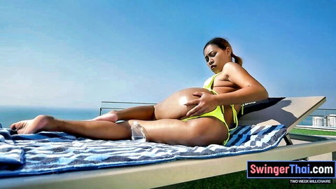 Pregnant Asian babe in yellow bikini posing seductively poolside in Thailand