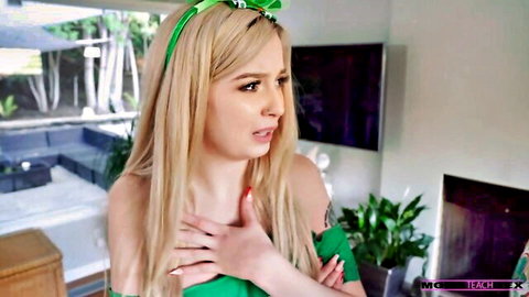Shocked blonde in green top clutches chest showing cleavage closeup