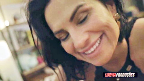 Close-up of smiling tanned brunette Latina MILF with sultry eyes and bare shoulders