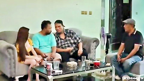 Indonesian woman in short shorts chats with three Asian guys on couch in homemade amateur video