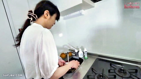 Japanese housewife washing dishes in kitchen wearing sheer white blouse teasing curves