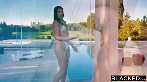 Brunette in skimpy white bikini teases poolside at luxury outdoor villa with wet hair
