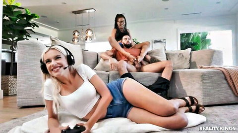Blonde gamer chick with headset plays while Kira Noir and James Angel watch, Reality Kings