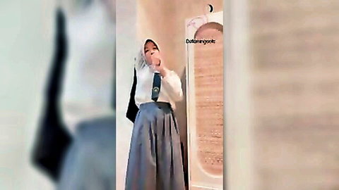 Indonesian woman in hijab and long skirt standing modestly in prayer room
